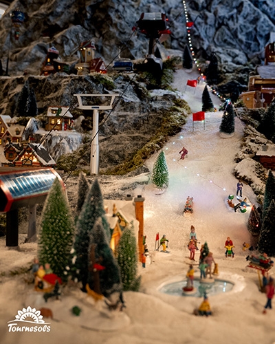 Village miniature Lemax enneigé avec piste de ski illuminée, figurines et chalets, proposé en déstockage à -50%.